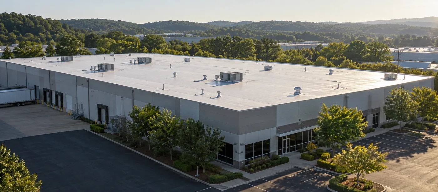 Low-slope commercial building surrounded by wooded hills in the Birmingham area